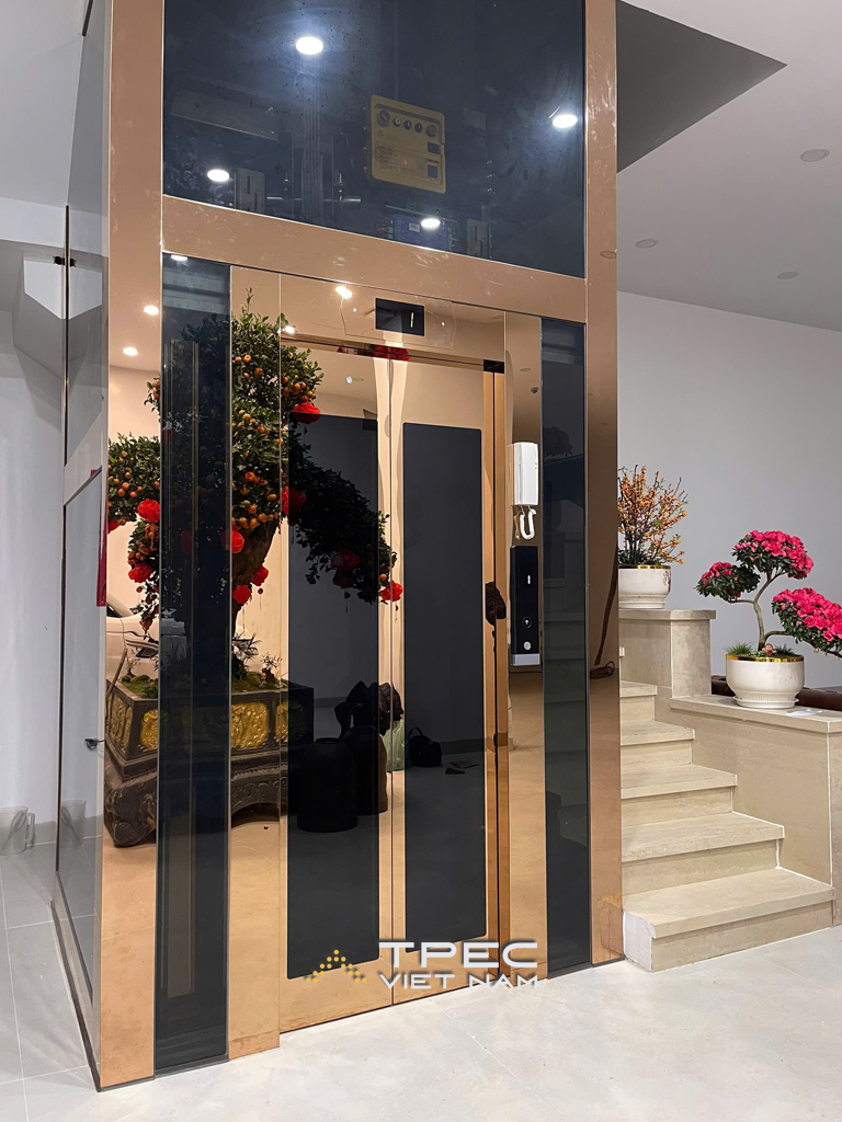 Thang máy kính gia đình khung ốp inox gương đồng lắp tại nhà phố Trần Quang Diệu