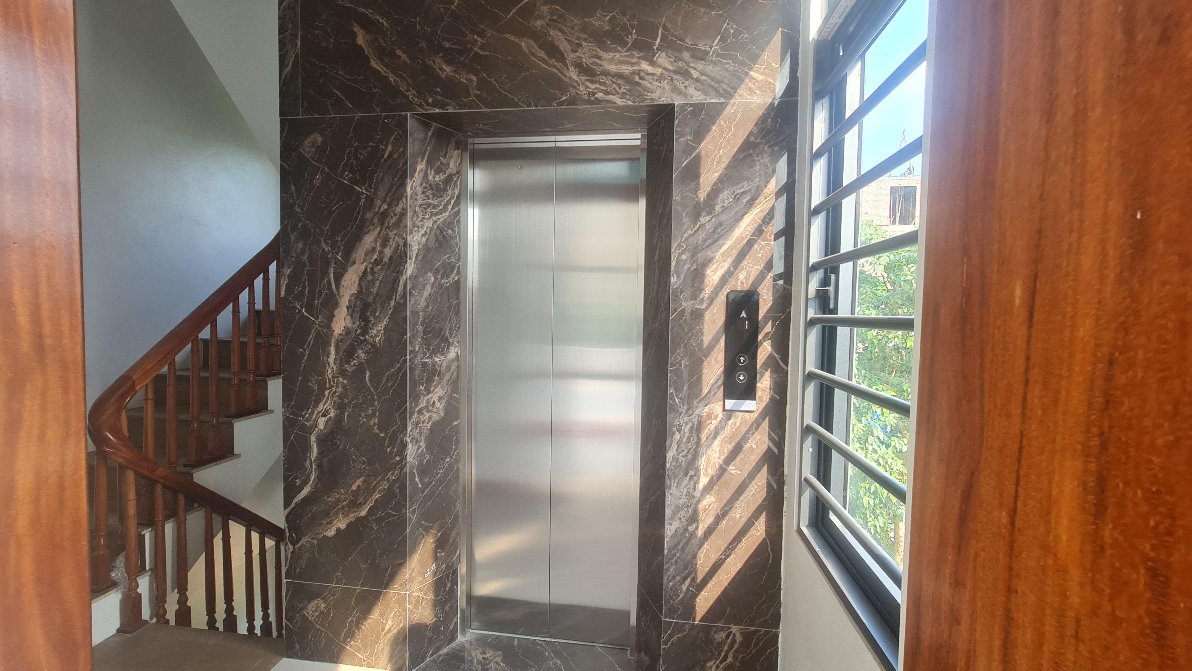 Cửa tầng inox sọc nhuyễn ốp đá marble cạnh cầu thang, thang máy 6 điểm dừng Bình Xuyên