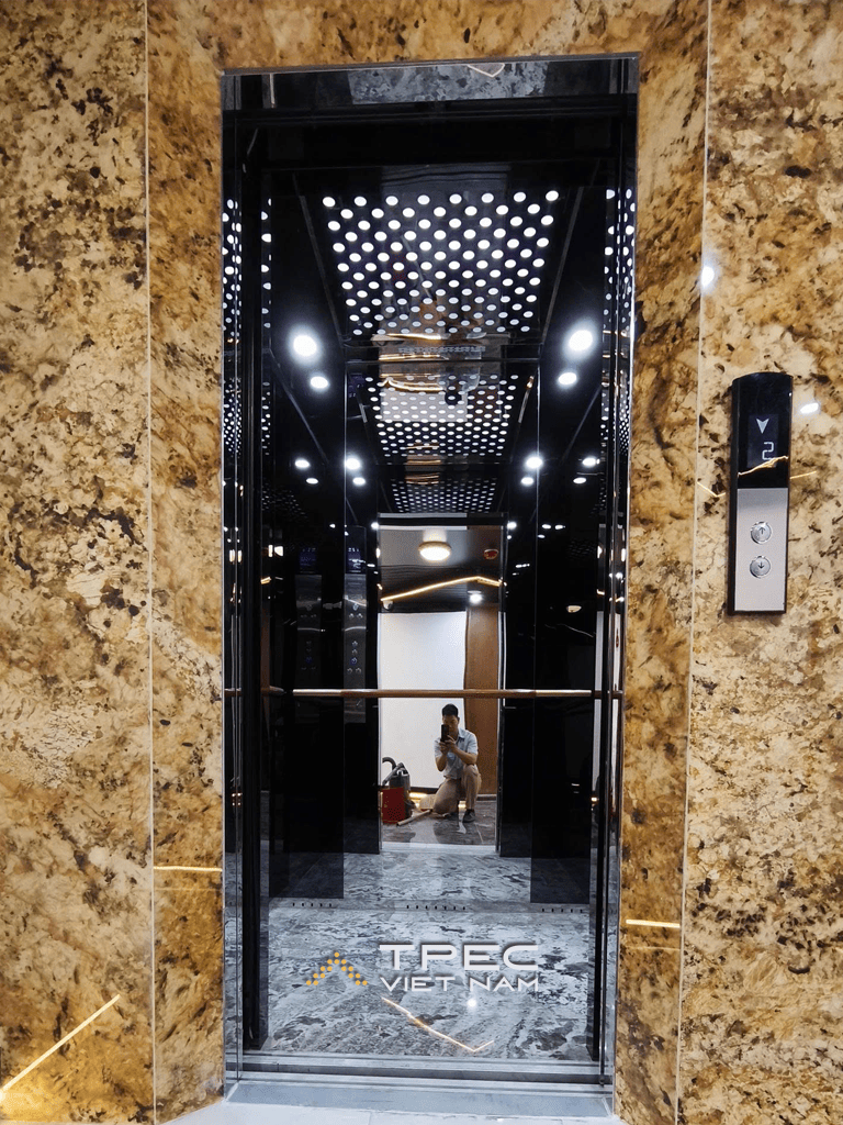 Cửa tầng thang máy tàu Aqua Luxury ốp đá hoa cương vàng, cabin gương đen bên trong