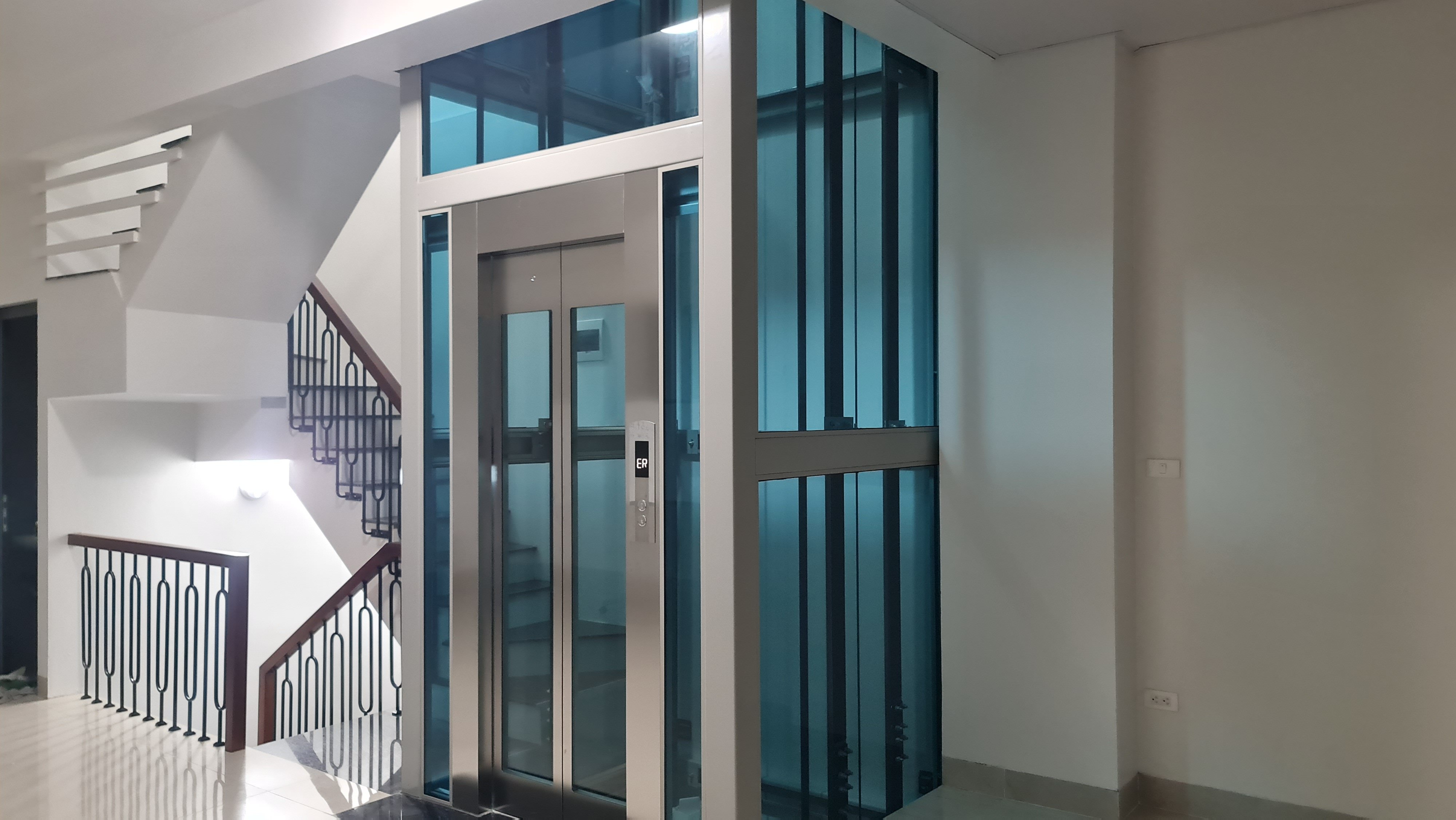 Thang máy kính 450kg khung nhôm vách kính xanh, cabin inox cạnh cầu thang, nhà phố Hạ Đình