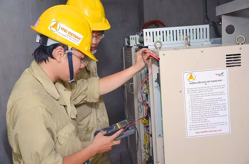 Kỹ thuật viên Thiên Thành Phát dùng đồng hồ đo kiểm tra tủ điều khiển khi sửa chữa thang máy