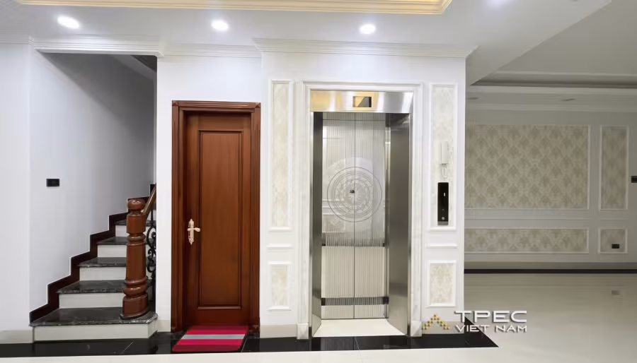 Thang máy gia đình 350kg lắp trong nhà phố cạnh cầu thang bộ và cửa gỗ