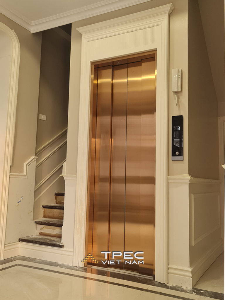 Thang máy inox vàng gương, khung cửa tân cổ điển trắng tại biệt thự Xanh Villas Thạch Thất