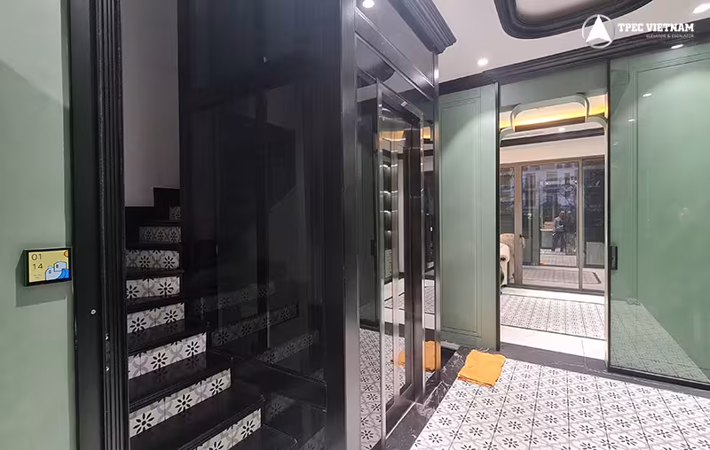 Thang máy gia đình cabin kính lắp cạnh cầu thang trong không gian nội thất hiện đại