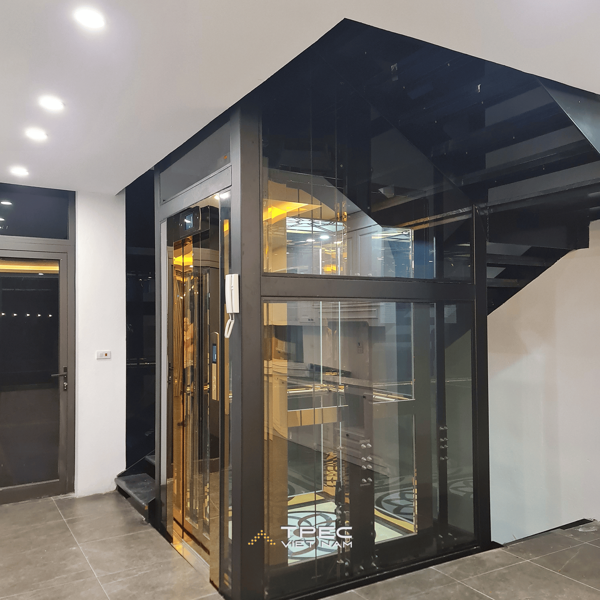 Cửa cabin inox gương vàng thang máy kính 630kg đặt cạnh cầu thang sắt, dự án tại Sơn Tây