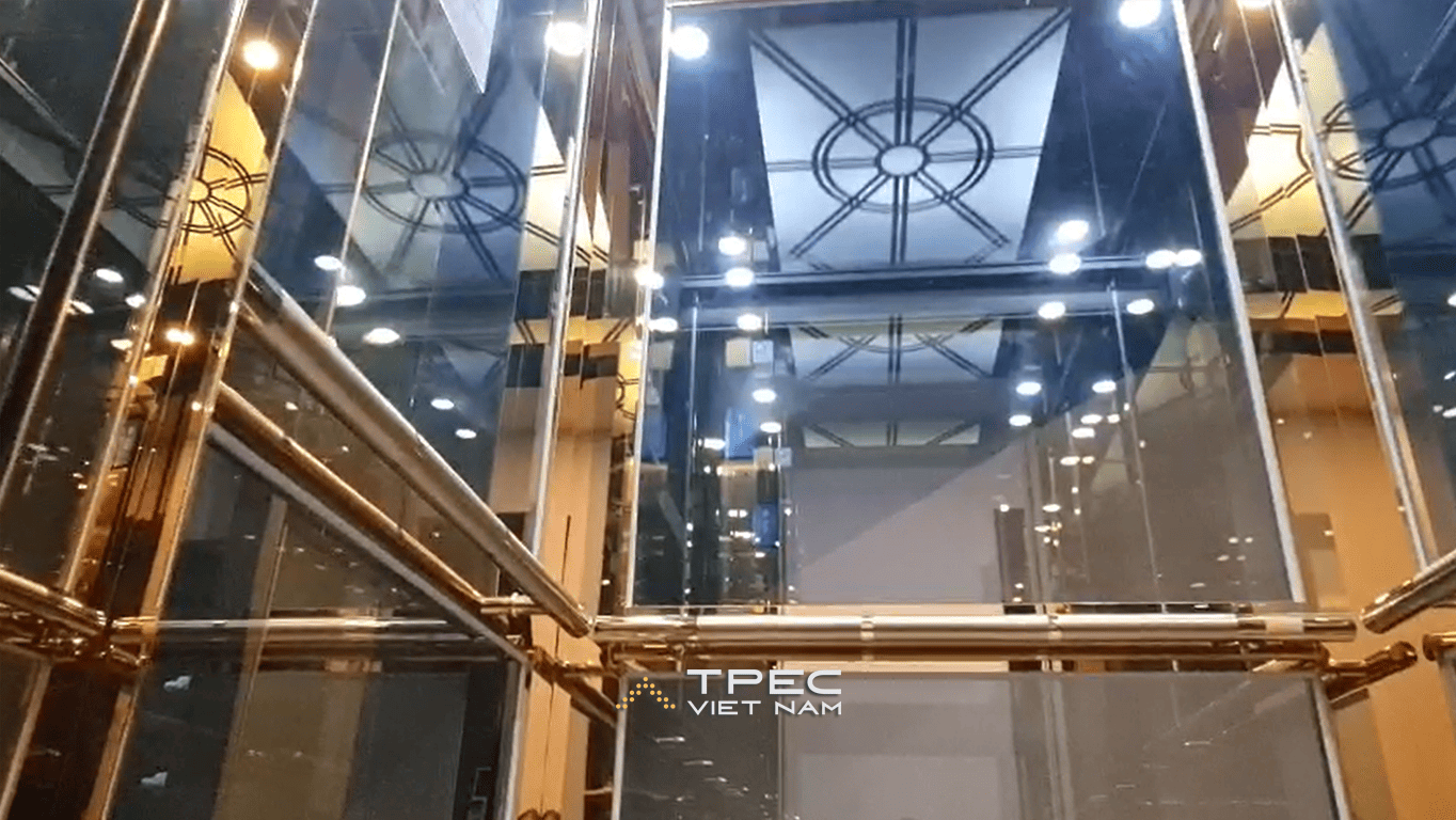 Góc nhìn từ dưới lên giếng thang kính và trần cabin vàng thang máy 630kg ở Sơn Tây
