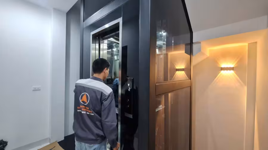 Nhân viên Thiên Thành Phát vận hành thang máy gia đình lồng kính vừa lắp đặt hoàn thiện