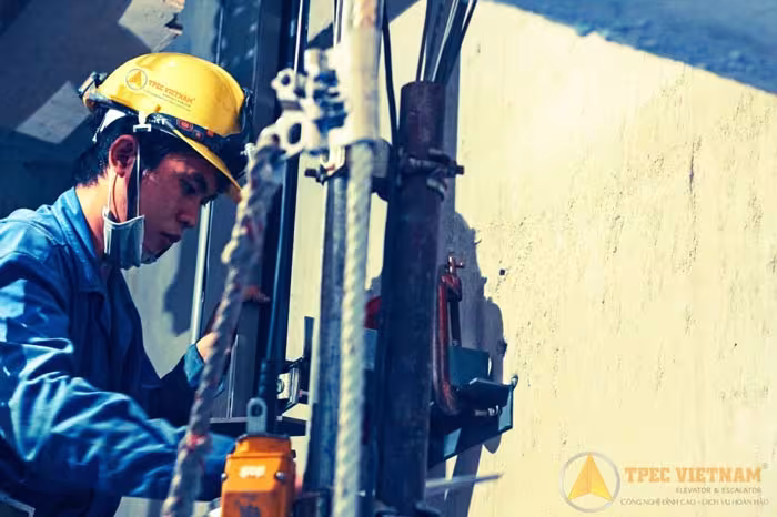 Công nhân lắp đặt thang máy cố định dây cáp treo tại công trình ngoài trời