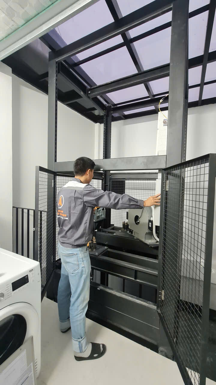 Kỹ thuật viên Thiên Thành Phát kiểm tra máy kéo trong phòng máy thang máy kính nhà phố Hà Đông