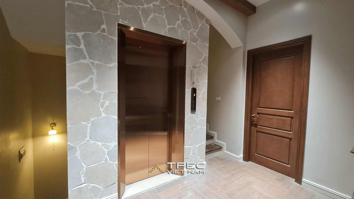 Cửa tầng thang máy inox đồng ốp đá tổ ong cạnh cầu thang biệt thự 450kg